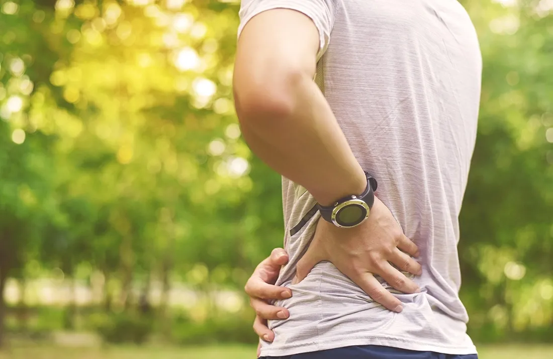 Close-up of a man experiencing hip pain while walking