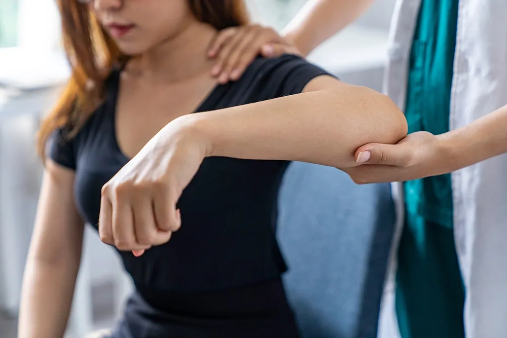 Woman in consultation with an elbow specialist and receiving medical assessment.