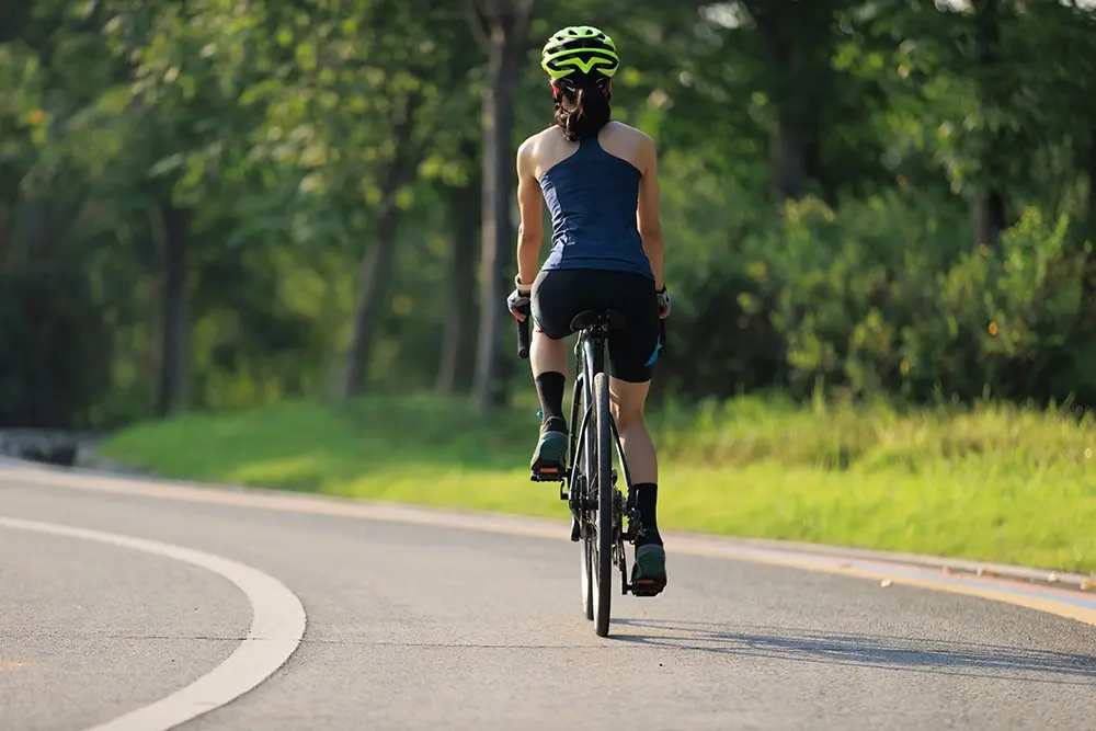 Woman cycling at a steady pace outdoors.
