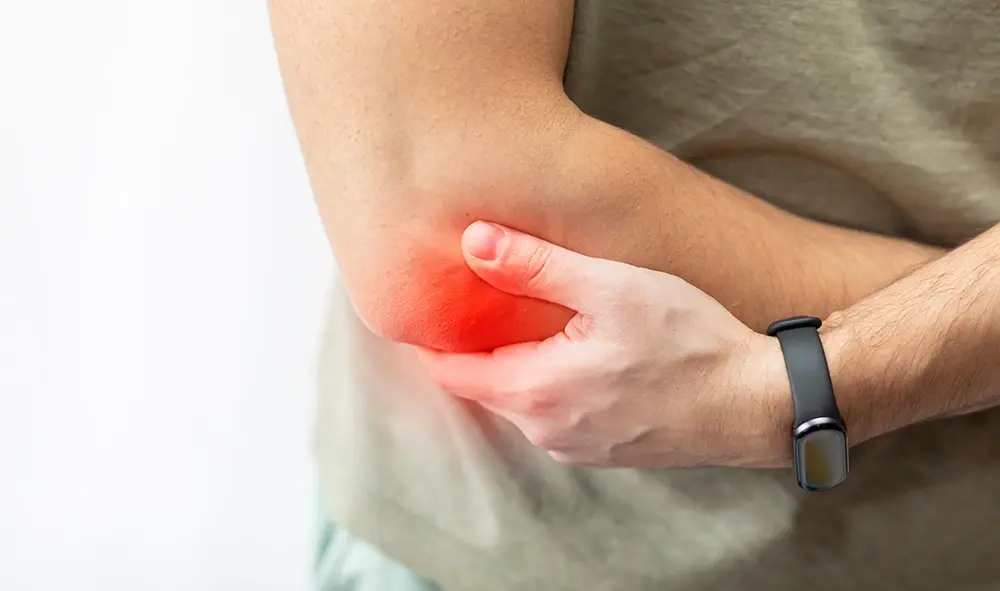 Man holding his elbow experiencing elbow pain.