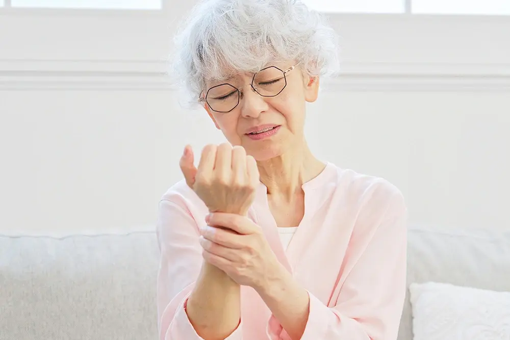 An elderly woman suffering from hand and wrist pain