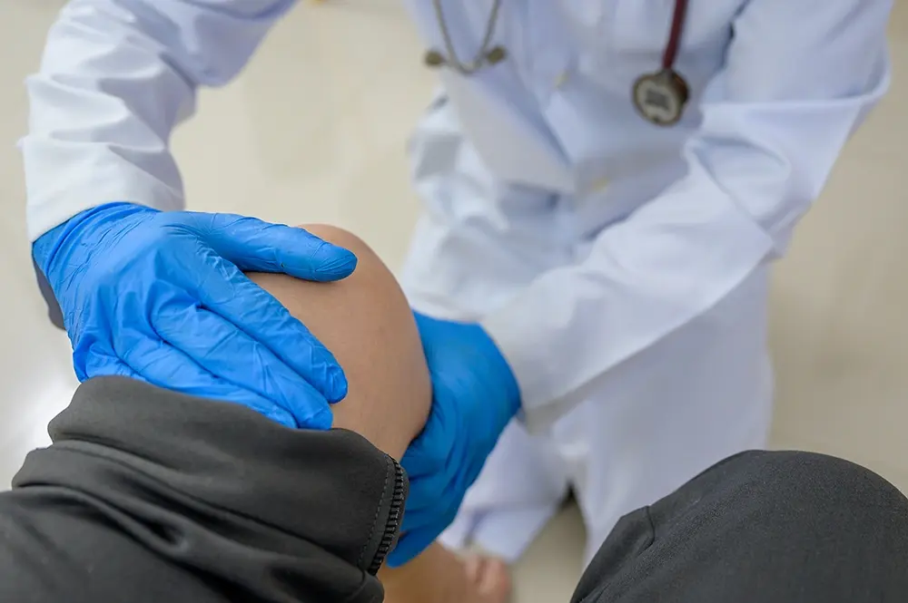 Knee surgeon performing a physical exam of a patient’s knee.