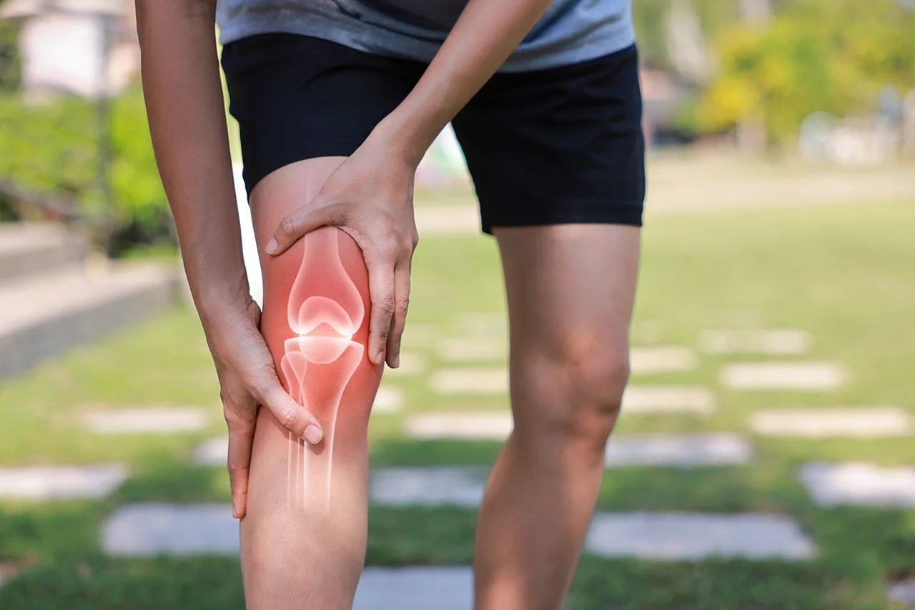 Man holding his knee while experiencing discomfort from a meniscus tear.