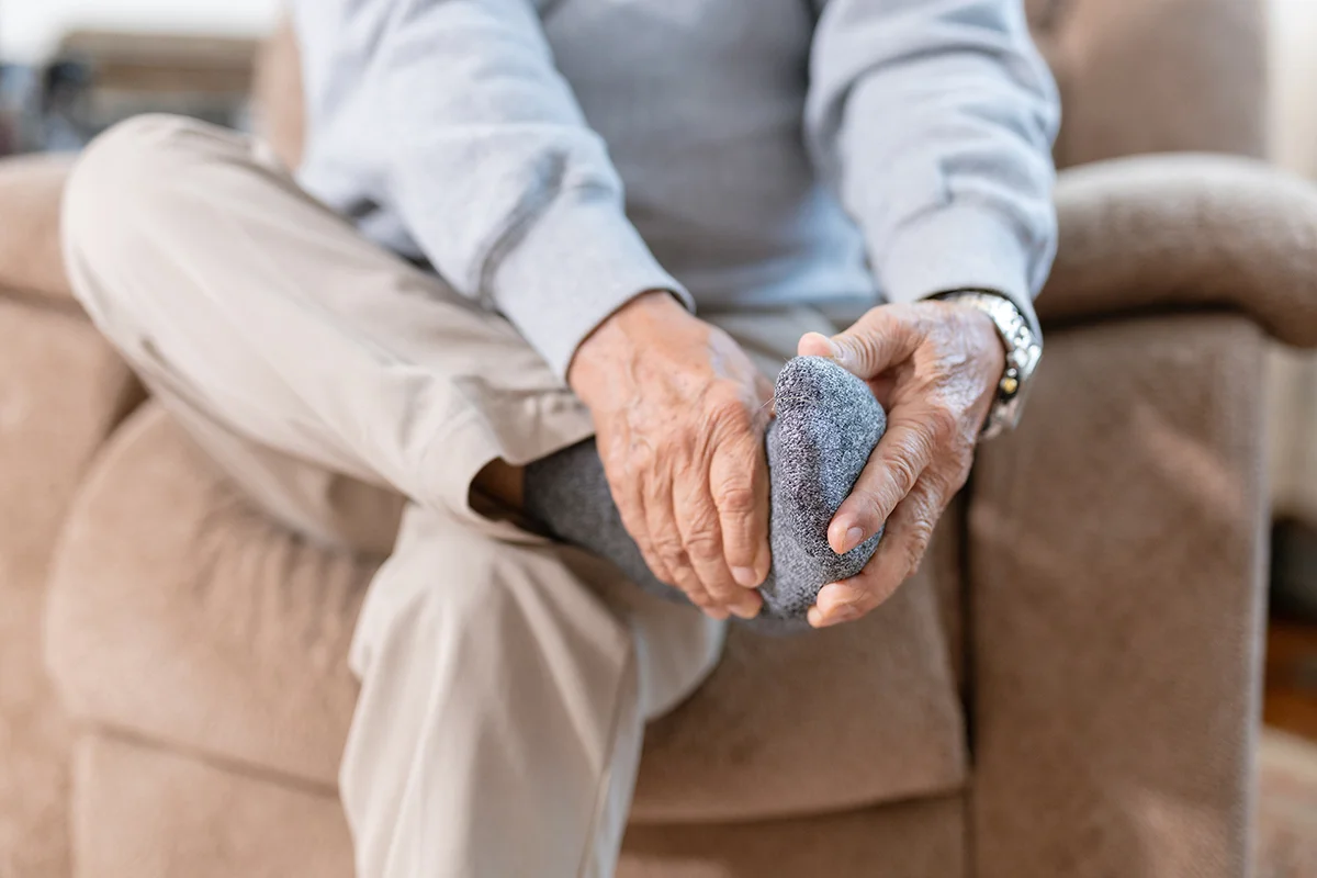 Elderly man experiencing foot pain due to arthritis