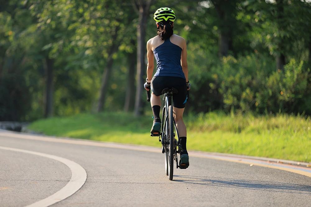Woman cycling at a steady pace outdoors.