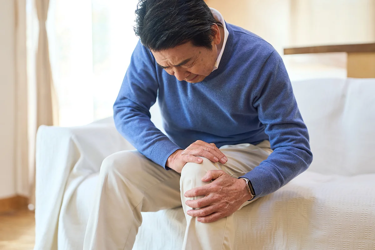 Middle-aged man holding his knee due to pain from a meniscus tear
