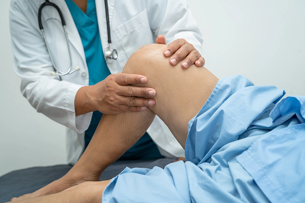 Knee replacement surgeon assessing patient’s knee