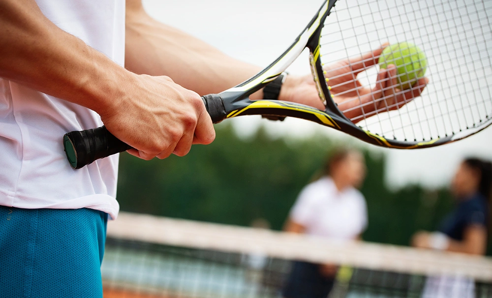 Man holding a tennis racket with correct playing form and posture.