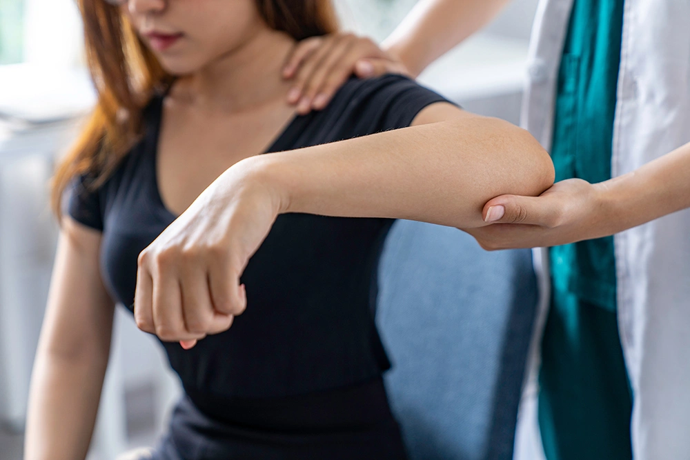 Woman in consultation with an elbow specialist and receiving medical assessment.