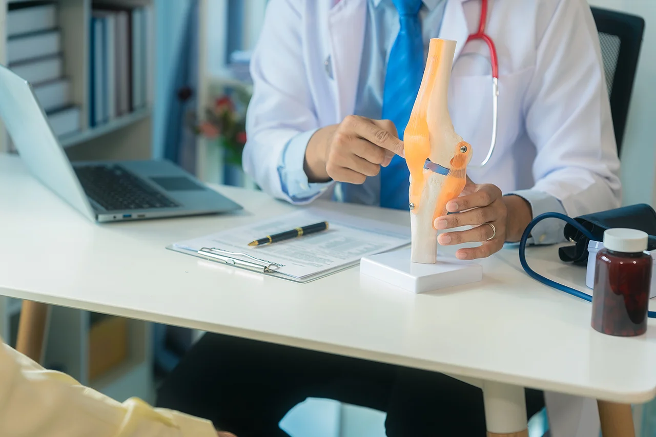 Orthopaedic surgeon in consultation with a patient about a persistent knee injury.