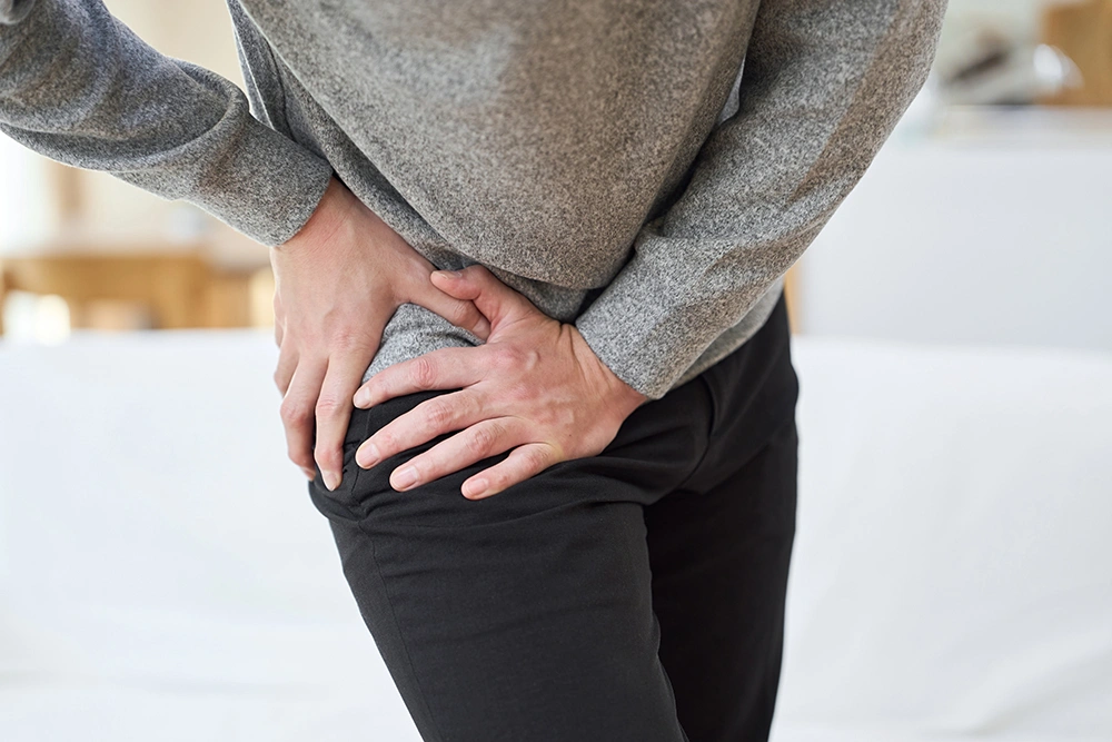 Man holding his hip in discomfort due to persistent hip pain.