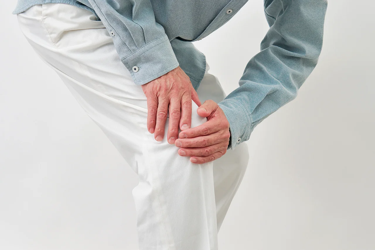 Man holding his knee and experiencing pain.